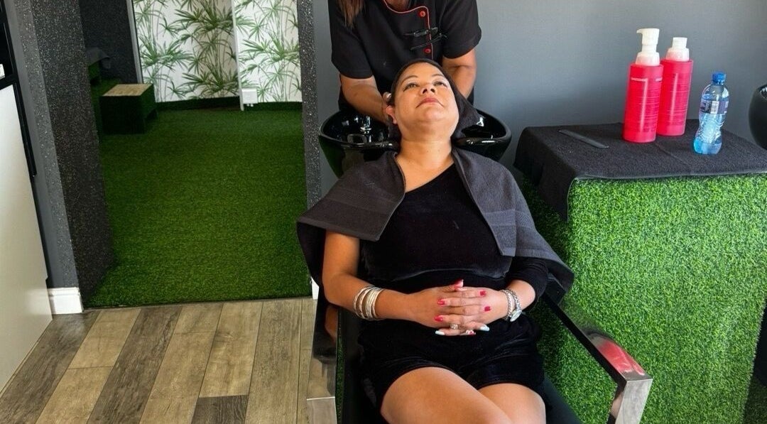 Relaxing hair wash at La Bella's Hair and Beauty Salon, Cape Town, Western Cape, ZA with lush green decor.