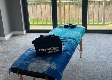 Massage table in serene room at Caitlin May Massage, Lichfield, England, GB with large windows and relaxing decor.