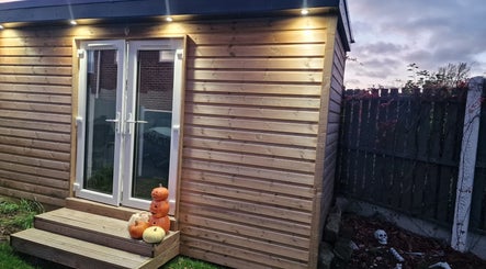 Wooden cabin entrance at J'adore Beauty Rooms, Normanton, England, GB, decorated with pumpkins and lights.
