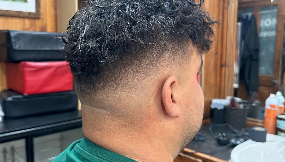 Curly hair fade styled at HairSystem Studio, Walton-on-Thames, England, GB. Cozy studio setting.