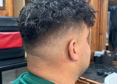 Curly hair fade styled at HairSystem Studio, Walton-on-Thames, England, GB. Cozy studio setting.