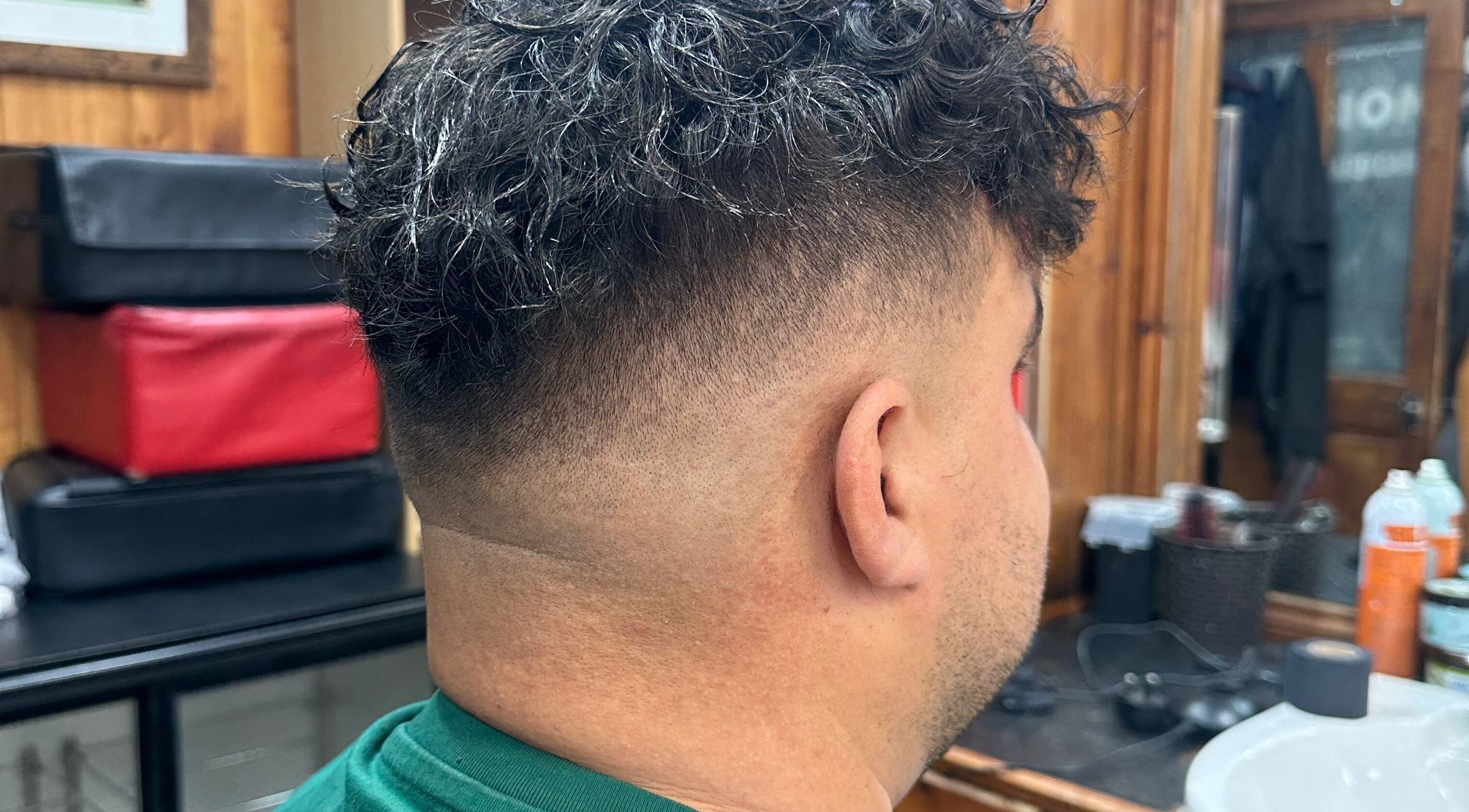 Curly hair fade styled at HairSystem Studio, Walton-on-Thames, England, GB. Cozy studio setting.