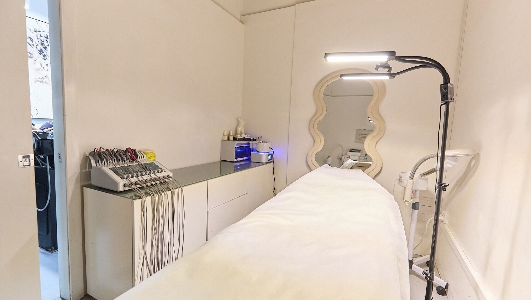 Serene treatment room at Gbeauty, Surry Hills, New South Wales, AU with modern equipment and elegant mirror.