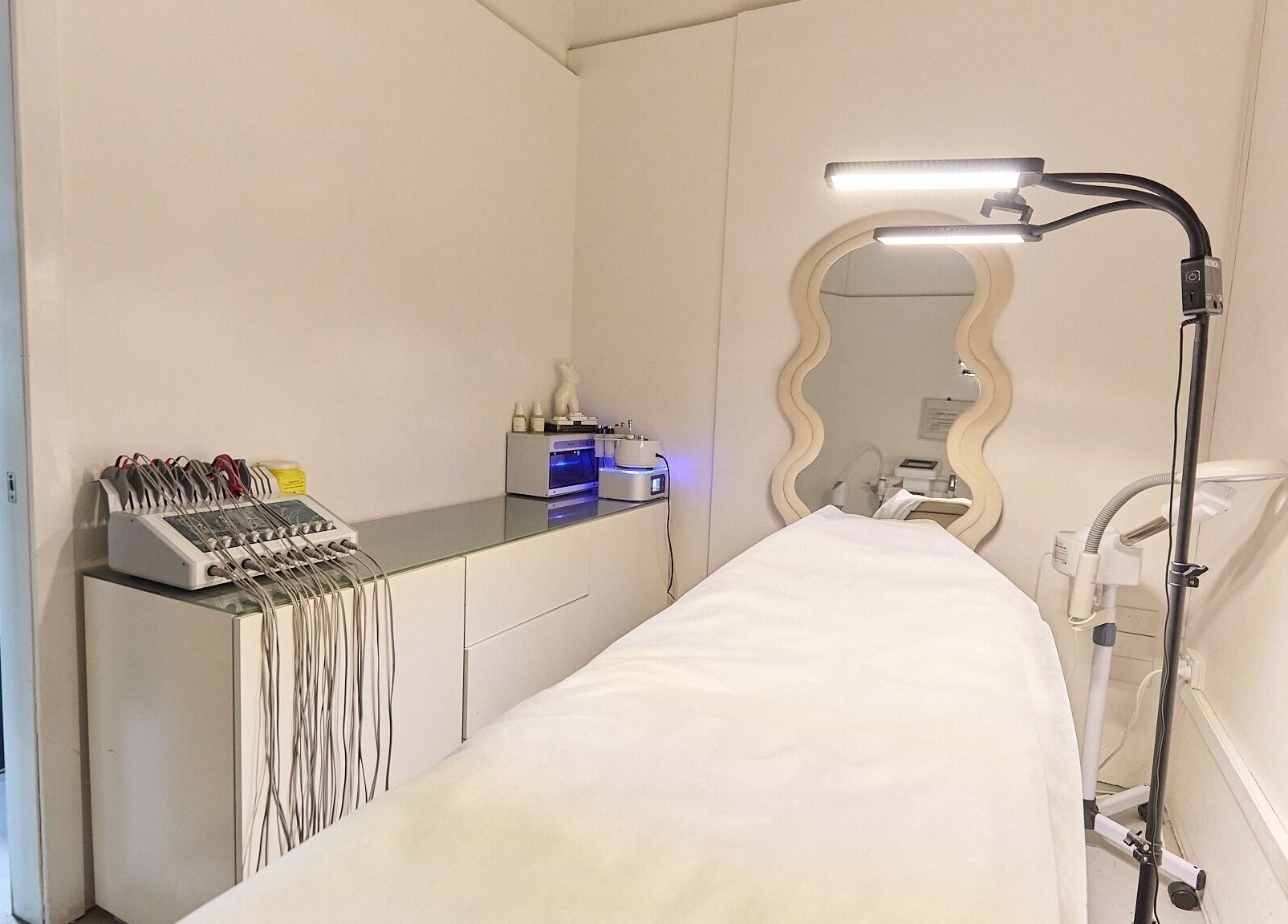 Serene treatment room at Gbeauty, Surry Hills, New South Wales, AU with modern equipment and elegant mirror.
