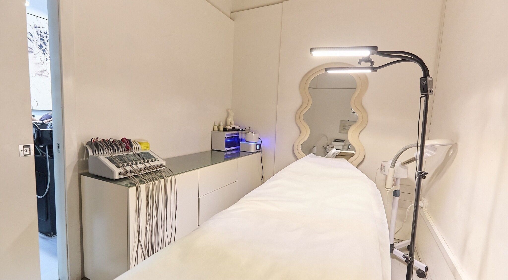 Serene treatment room at Gbeauty, Surry Hills, New South Wales, AU with modern equipment and elegant mirror.