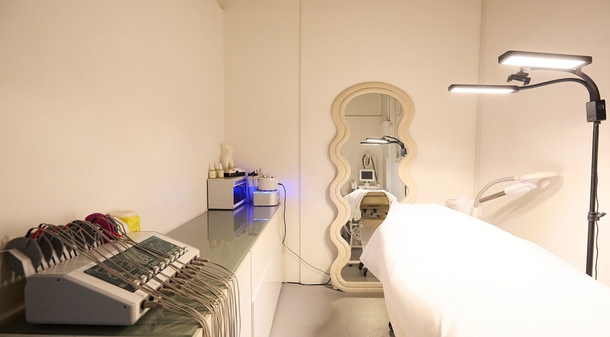 Modern beauty treatment room at Gbeauty, Surry Hills, New South Wales, AU with equipment and a stylish mirror.