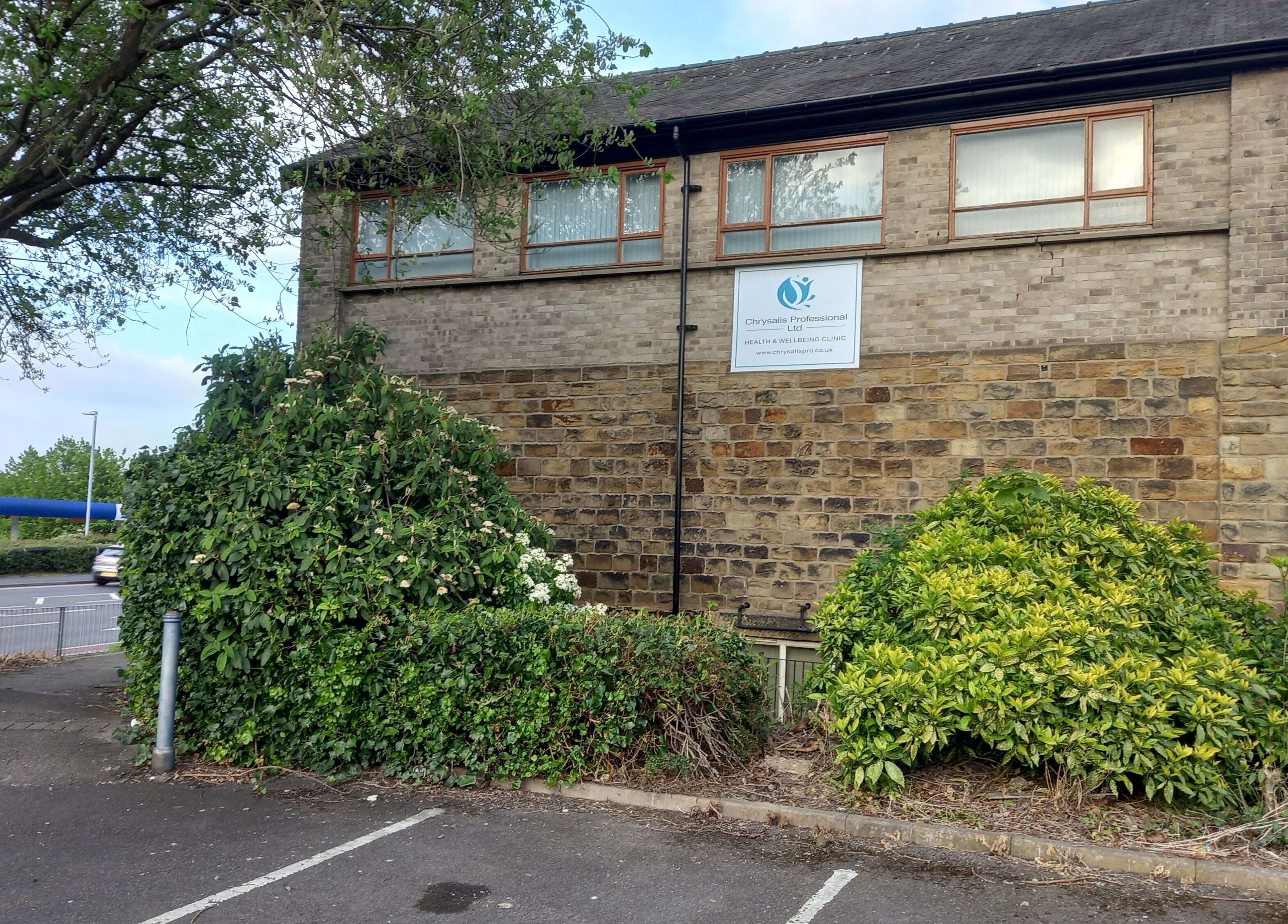 Exterior of Skin2Sole in Wath Upon Dearne, England, GB, with lush greenery and stone architecture.