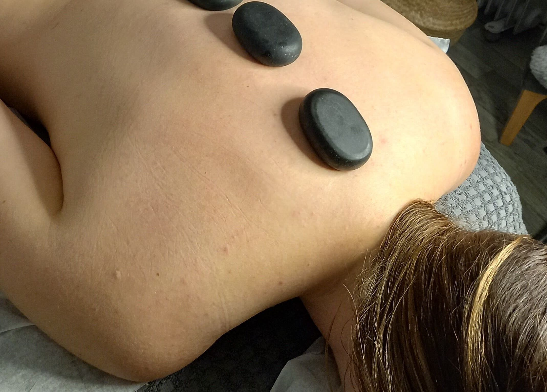 Hot stone therapy at Skin2Sole, Wath Upon Dearne, England, GB. Relaxing massage with warm stones on back.