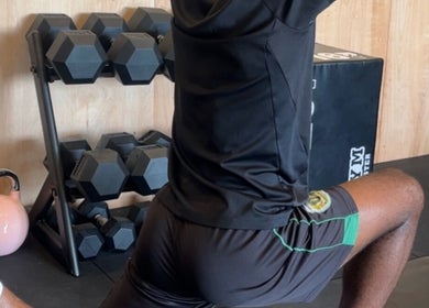 Person stretching in workout gear at Sport Spa Ltd, London, England, GB, surrounded by gym equipment.