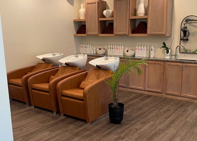 Elegant wash area at Alora Salon, Pittsburgh, Pennsylvania, US with leather chairs and stylish decor.