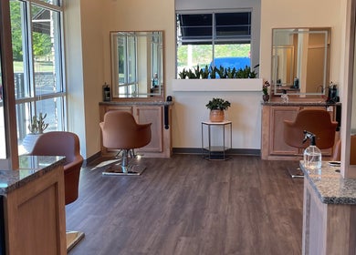 Spacious interior of Alora Salon in Pittsburgh, Pennsylvania, US. Elegant chairs and mirrors adorn the stylish setting.