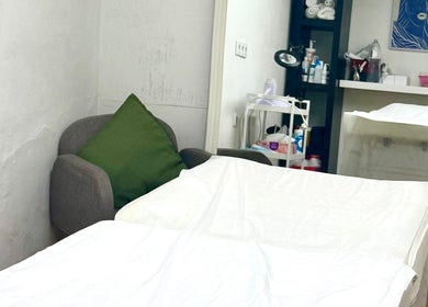 Quarto de tratamento em Studio DeVitto, Amadora, Lisboa, PT com mesa de massagem e poltrona confortável.