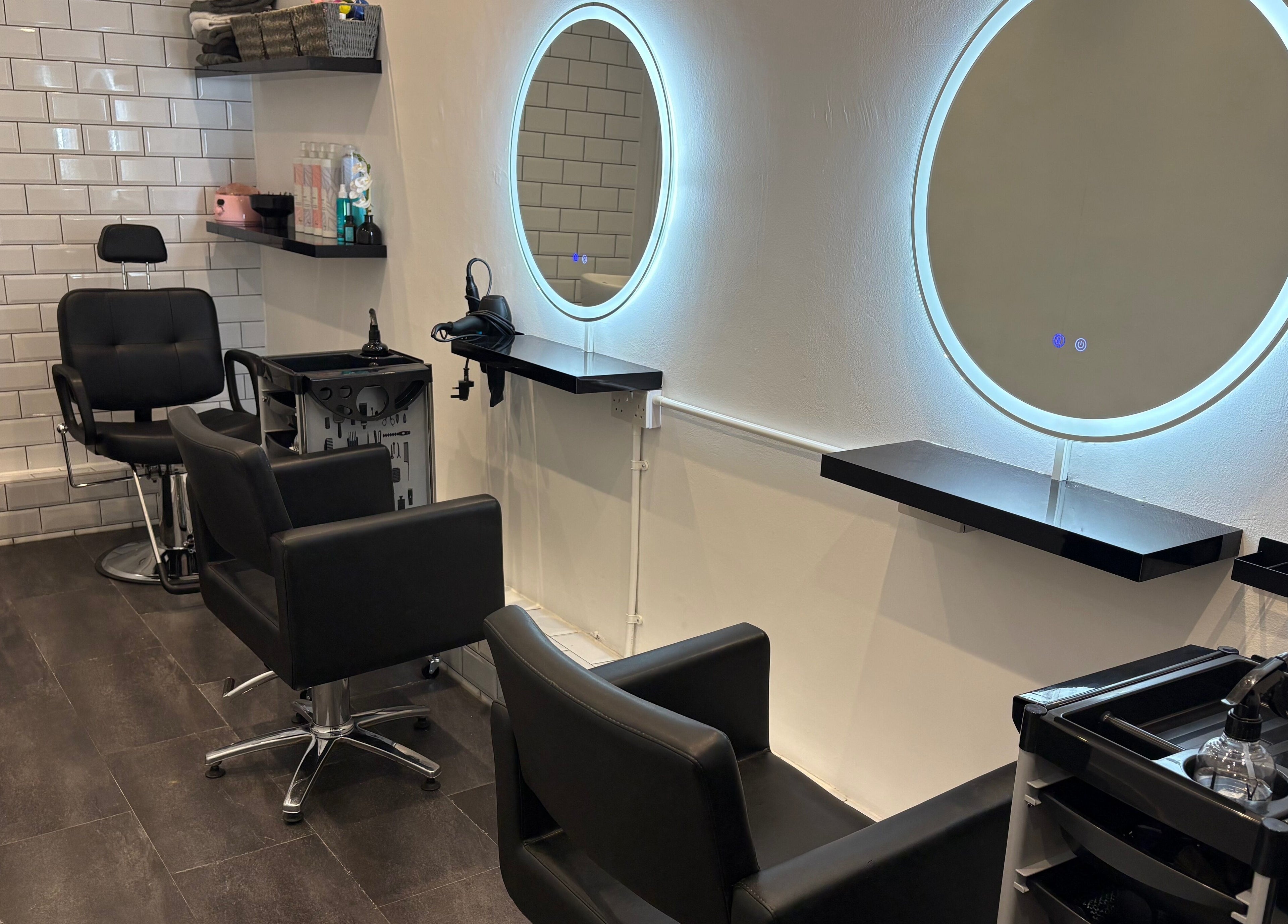 Modern salon setup at The Little Hair Room, Ayr, Scotland, GB with illuminated mirrors and styling chairs.