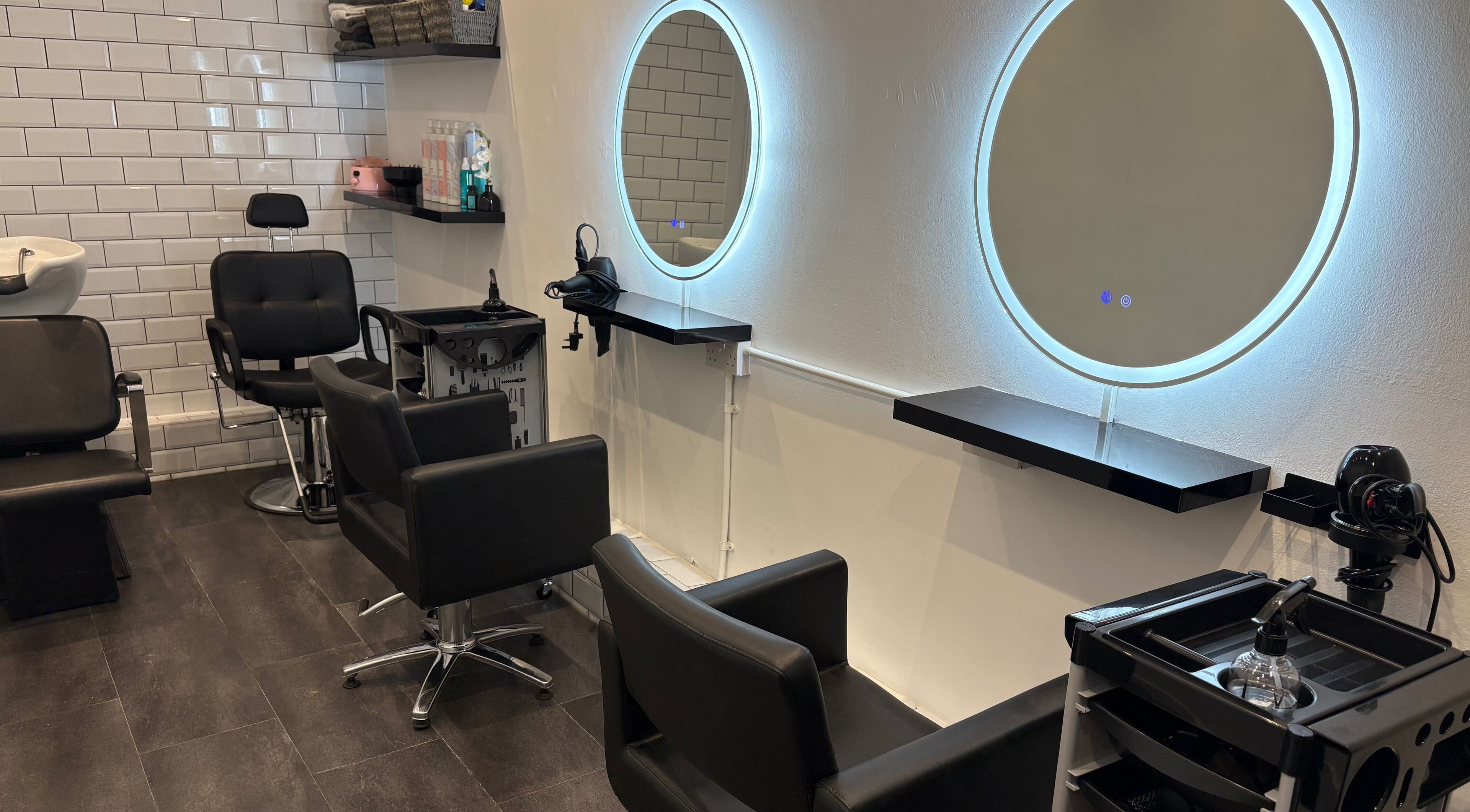 Modern salon setup at The Little Hair Room, Ayr, Scotland, GB with illuminated mirrors and styling chairs.