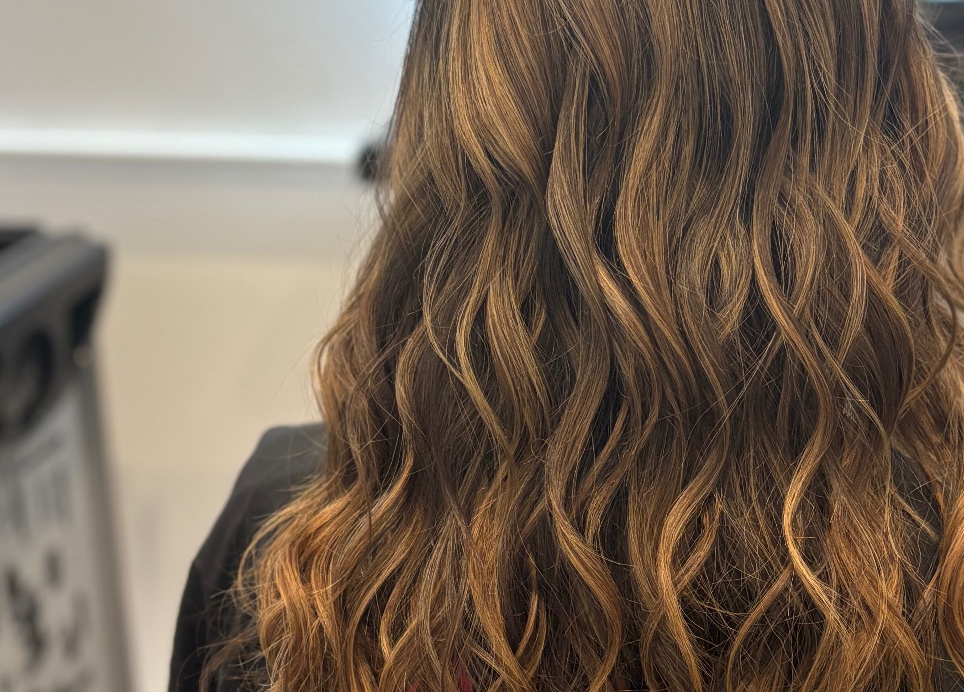 Close-up of wavy brown hair styled at The Little Hair Room, Ayr, Scotland, GB, showcasing texture and shine.
