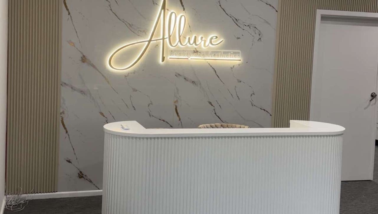 Reception desk at Allure Beauty and Aesthetics Paralowie, featuring a marble backdrop, Paralowie, South Australia, AU.