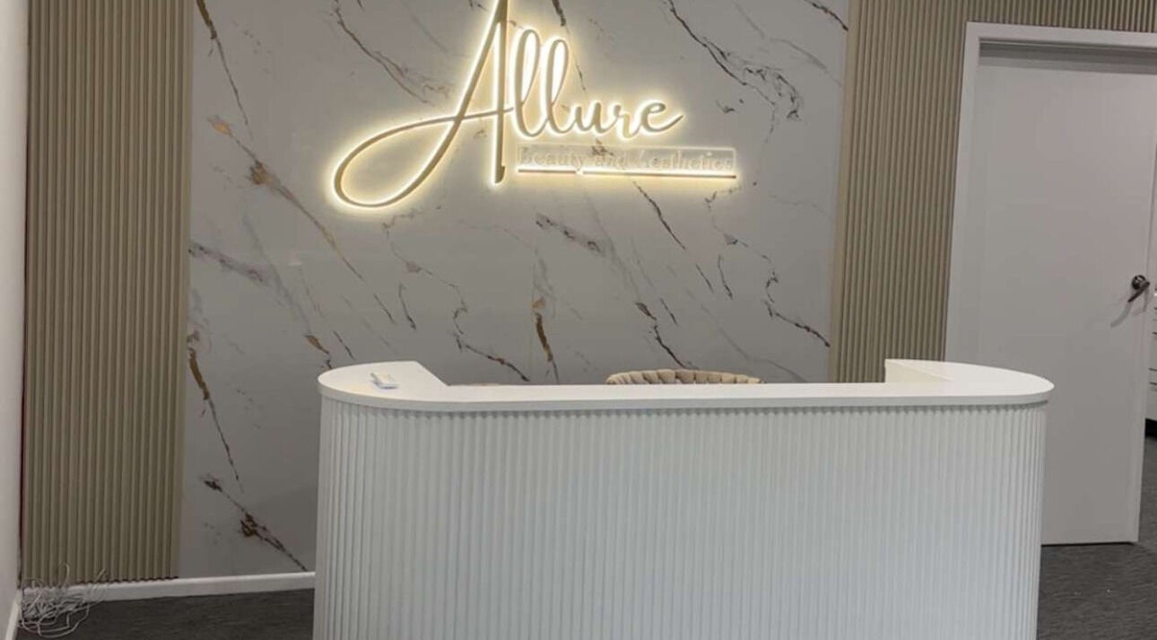 Reception desk at Allure Beauty and Aesthetics Paralowie, featuring a marble backdrop, Paralowie, South Australia, AU.