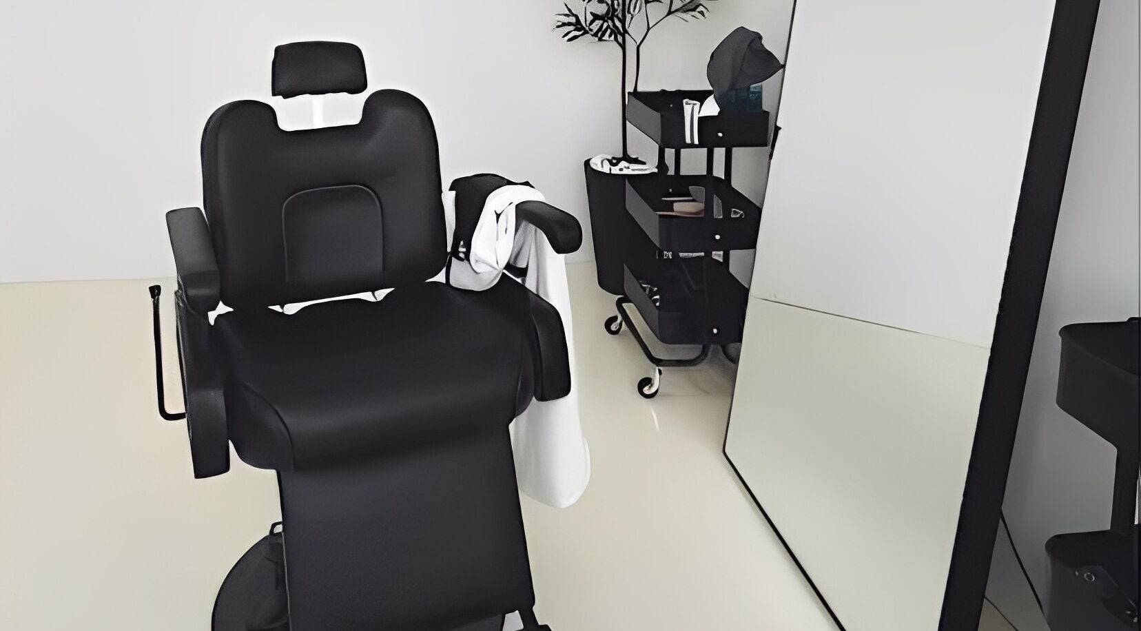 Modern salon chair in Kami Studio, Singapore, SG, with mirror and tools trolley nearby for a serene beauty experience.