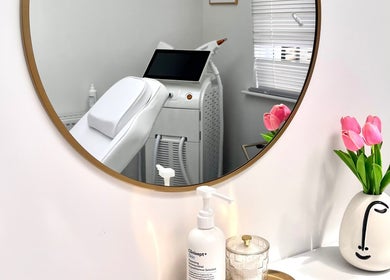 Modern treatment room at The Bloom Aesthetics, Hereford, England, GB, featuring elegant decor and pink tulips.