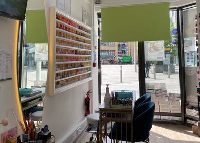 Interior of Sky Nails in Brentford, England, showcasing colorful nail polish displays in modern design.