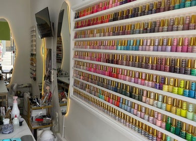 Vibrant nail polish display at Sky Nails in Brentford, England, GB highlights extensive color selection and chic decor.