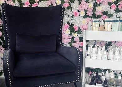Elegant chair and skincare display in Divine Touch, Wolverhampton, England, GB with floral wall backdrop.