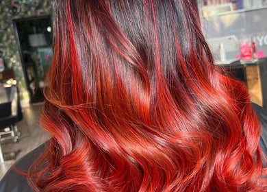 Vibrant red ombre hair styled at Painted by Will, Harrogate, England, GB showcasing salon's artistic flair.