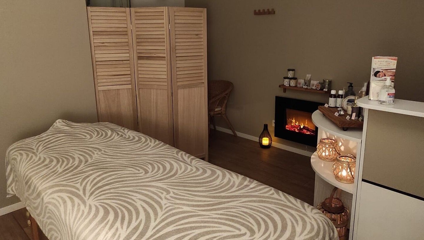 Salle de massage relaxante à Instants d Evasion, La Vacherie, Normandie, FR avec cheminée et bougies.