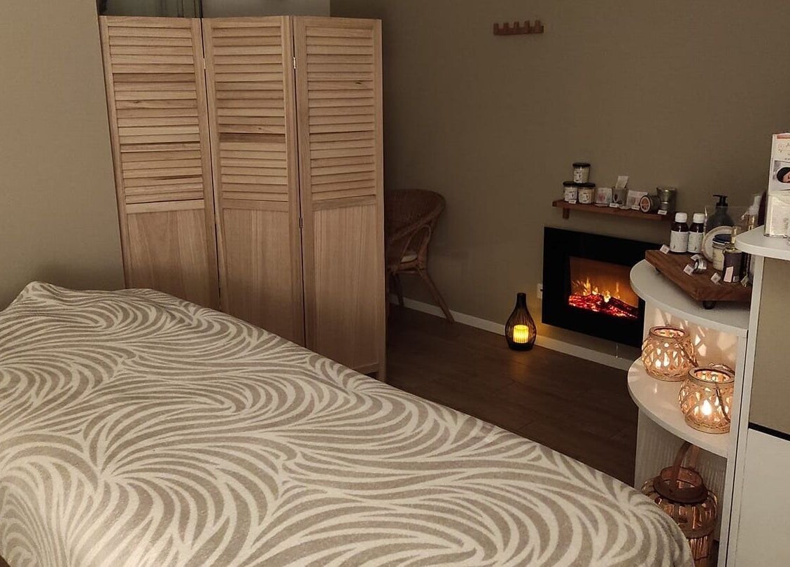 Salle de massage relaxante à Instants d Evasion, La Vacherie, Normandie, FR avec cheminée et bougies.