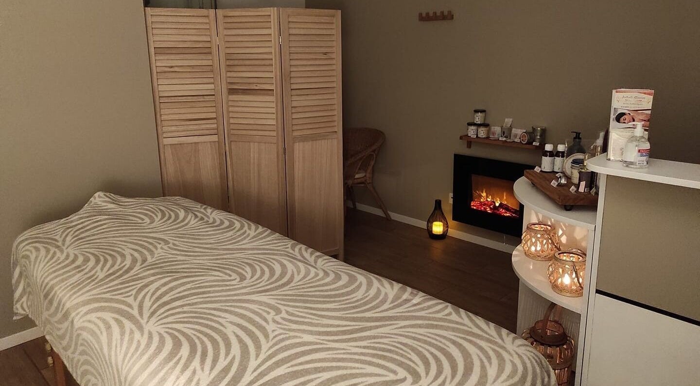 Salle de massage relaxante à Instants d Evasion, La Vacherie, Normandie, FR avec cheminée et bougies.