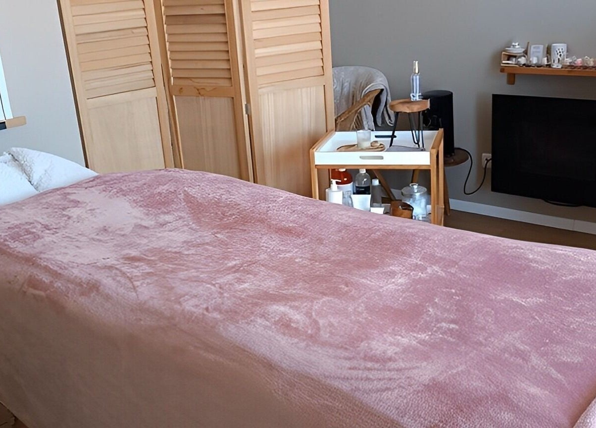 Salle de massage accueillante à Instants d Evasion, La Vacherie, Normandie, FR avec couverture rose et équipements spa.