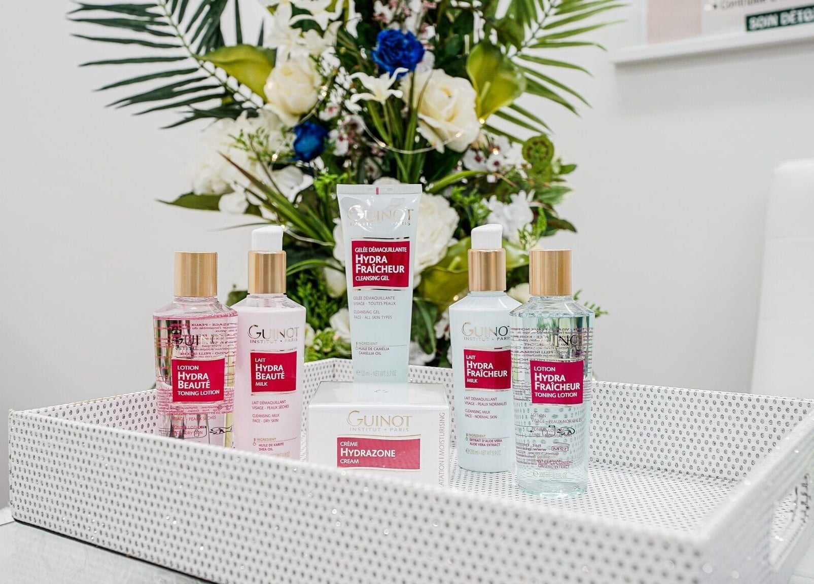 Produits Guinot sur un plateau à Clinique Lafayette Médico-Esthétique, Montréal, Québec, CA. Décor élégant et floral.