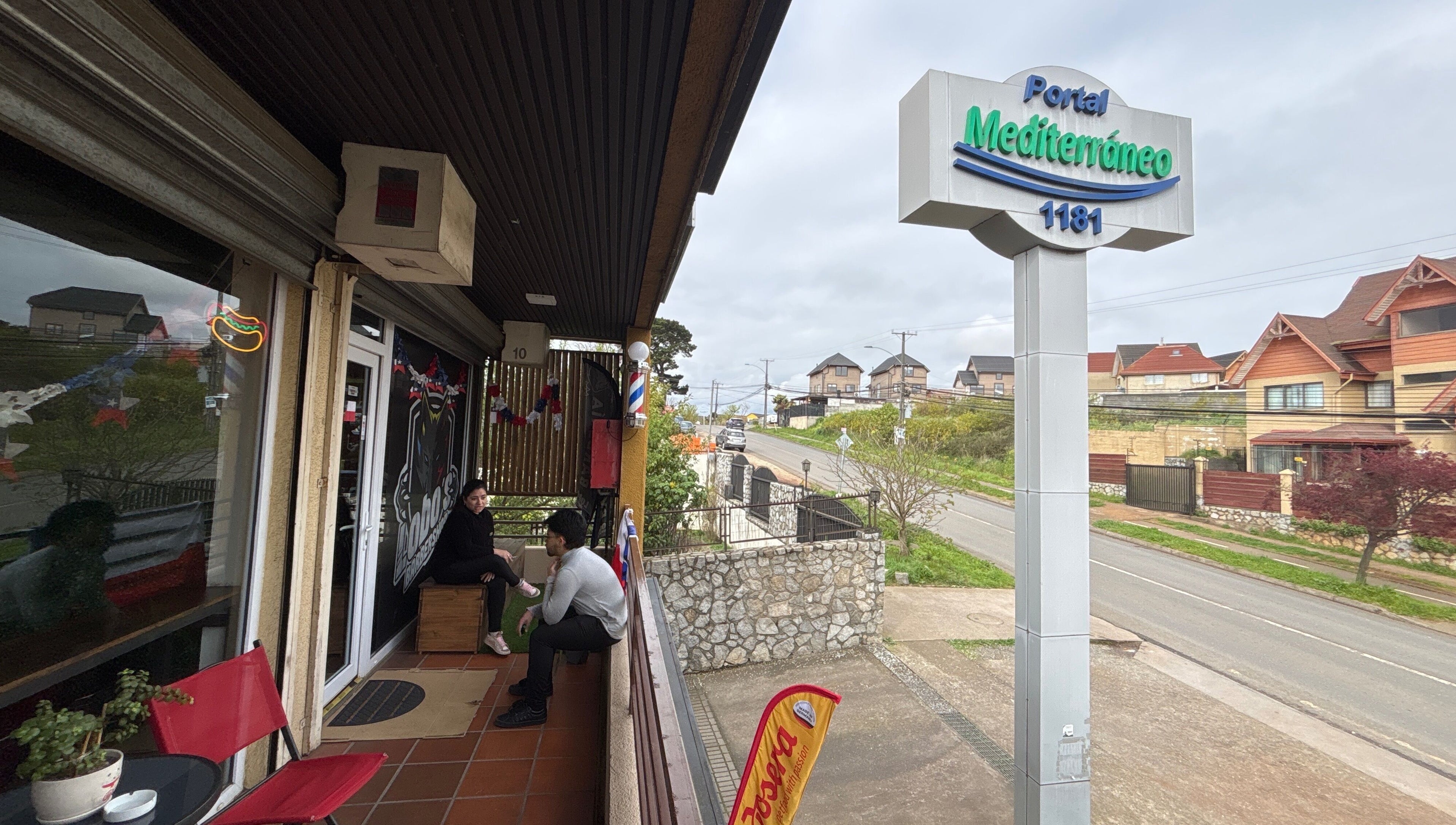 Entrada del Lobosbarbershop en Concepción, Bío Bío, CL, mostrando áreas exteriores y letrero del Portal Mediterráneo.