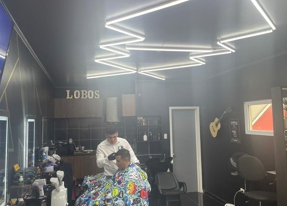 Interior de Lobosbarbershop en Concepción, Bío Bío, CL. Cliente recibiendo corte en ambiente moderno y elegante.