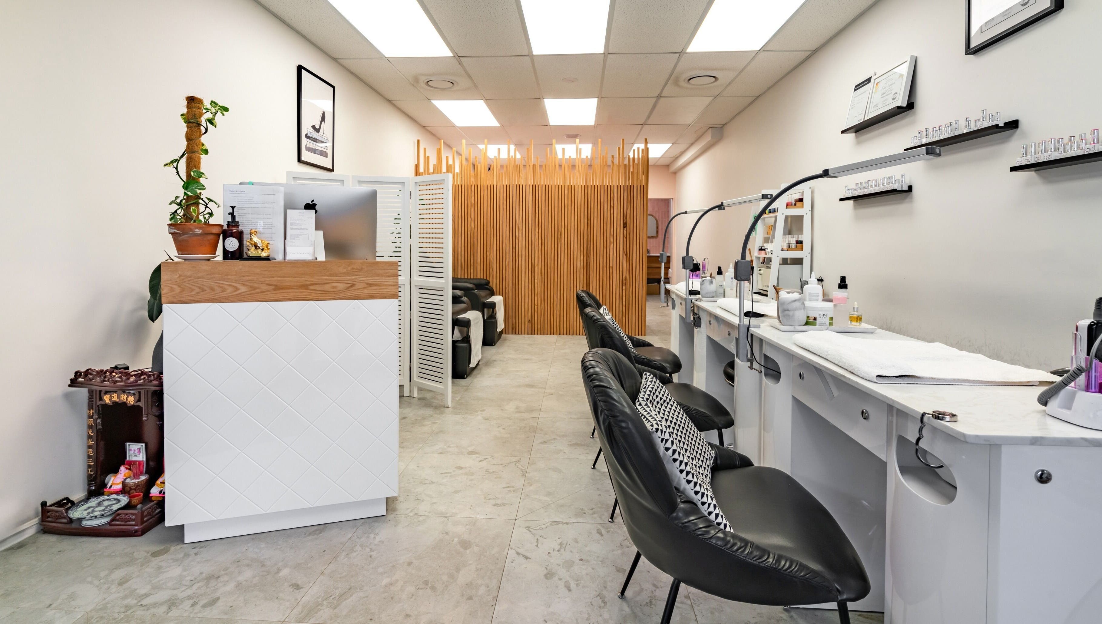 Modern nail salon interior at Flutter & Co, Auckland, NZ, featuring stylish chairs and decor.
