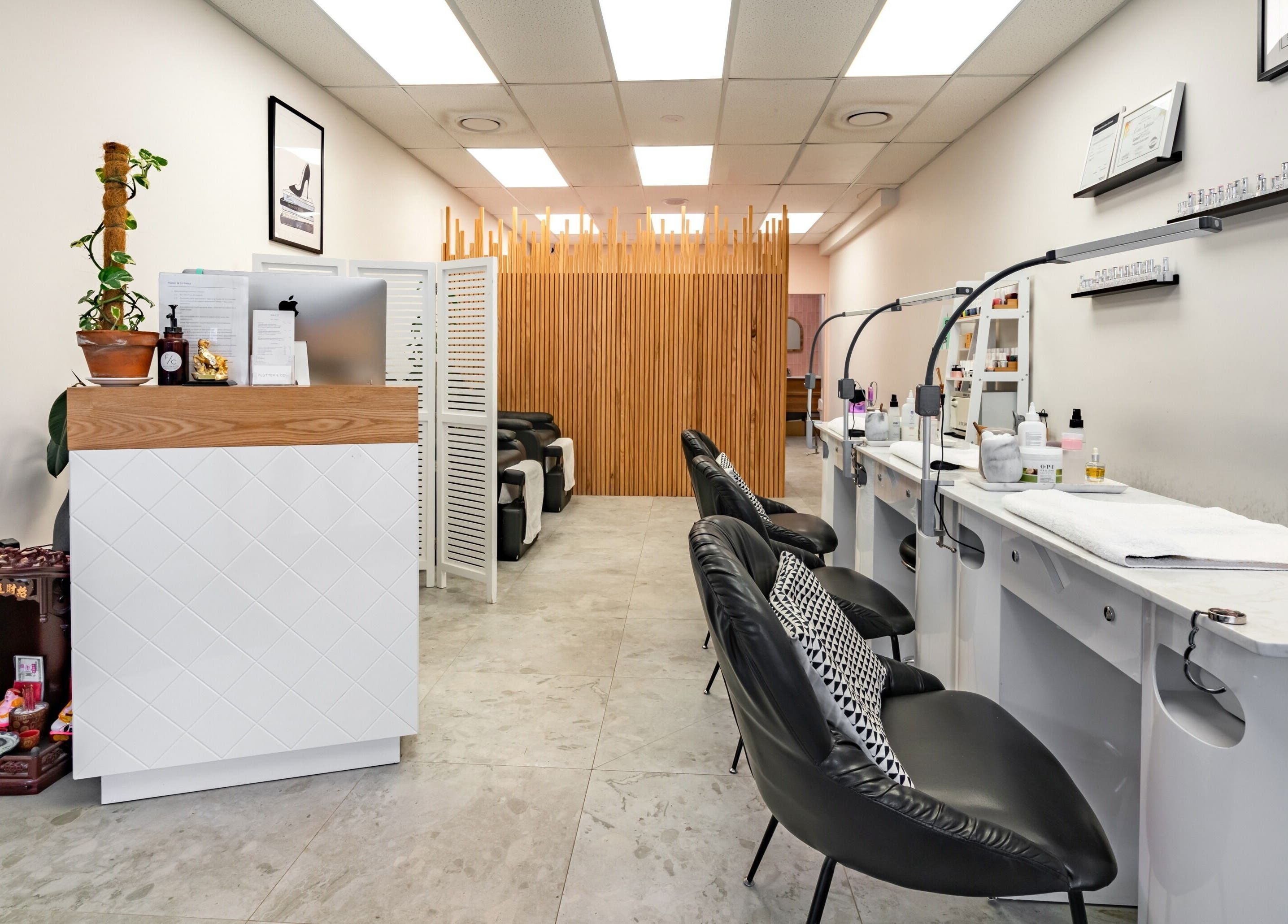 Modern nail salon interior at Flutter & Co, Auckland, NZ, featuring stylish chairs and decor.