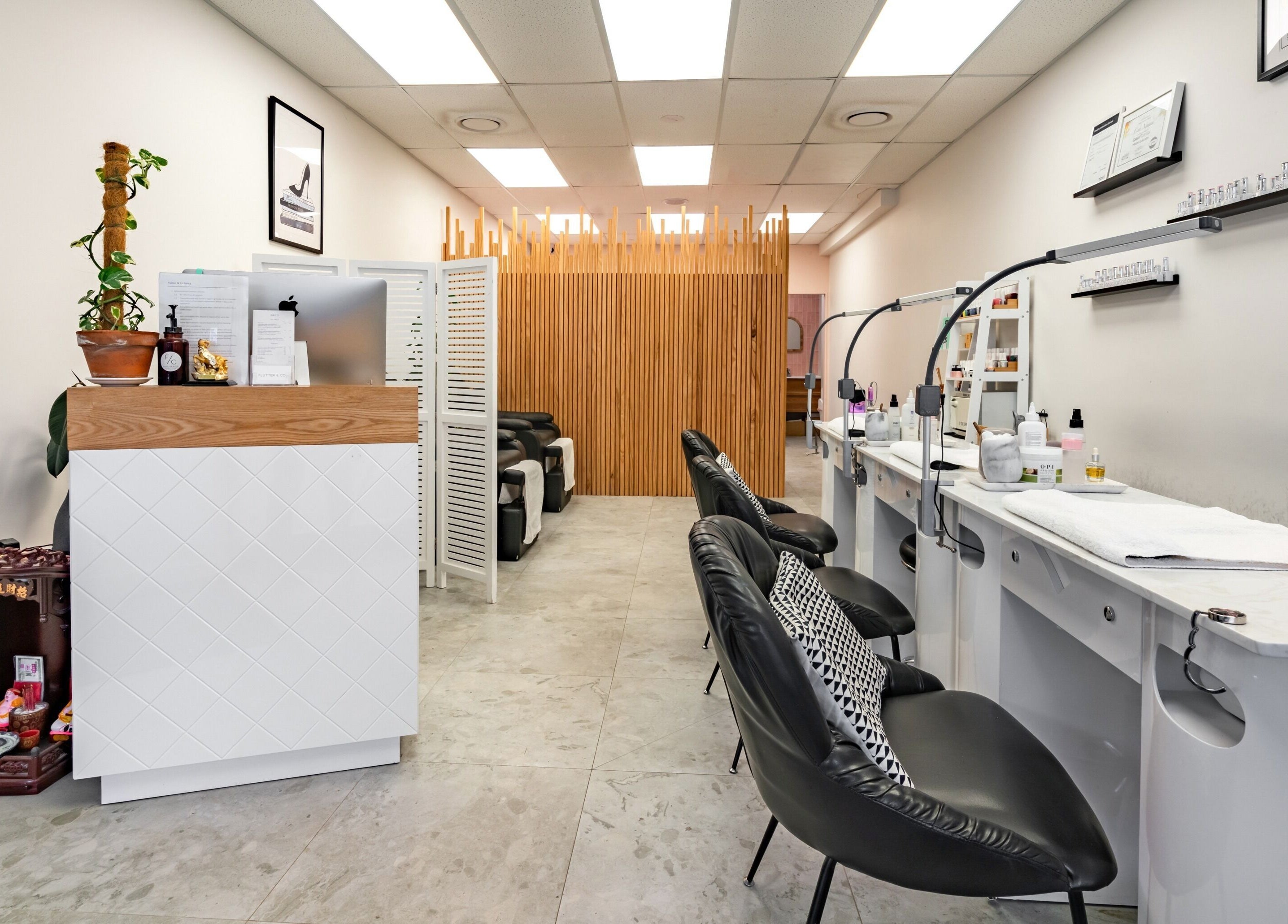 Modern nail salon interior at Flutter & Co, Auckland, NZ, featuring stylish chairs and decor.