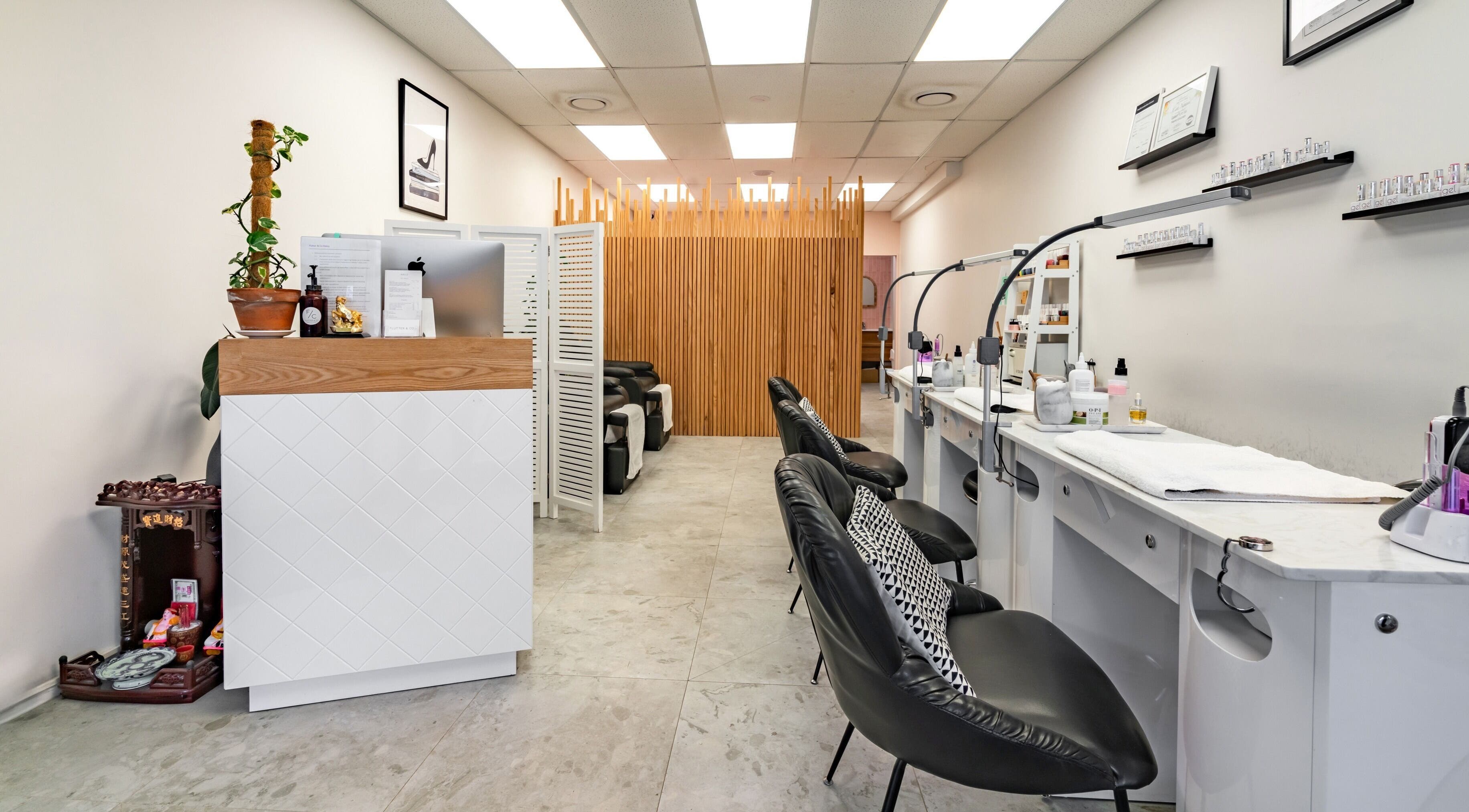 Modern nail salon interior at Flutter & Co, Auckland, NZ, featuring stylish chairs and decor.
