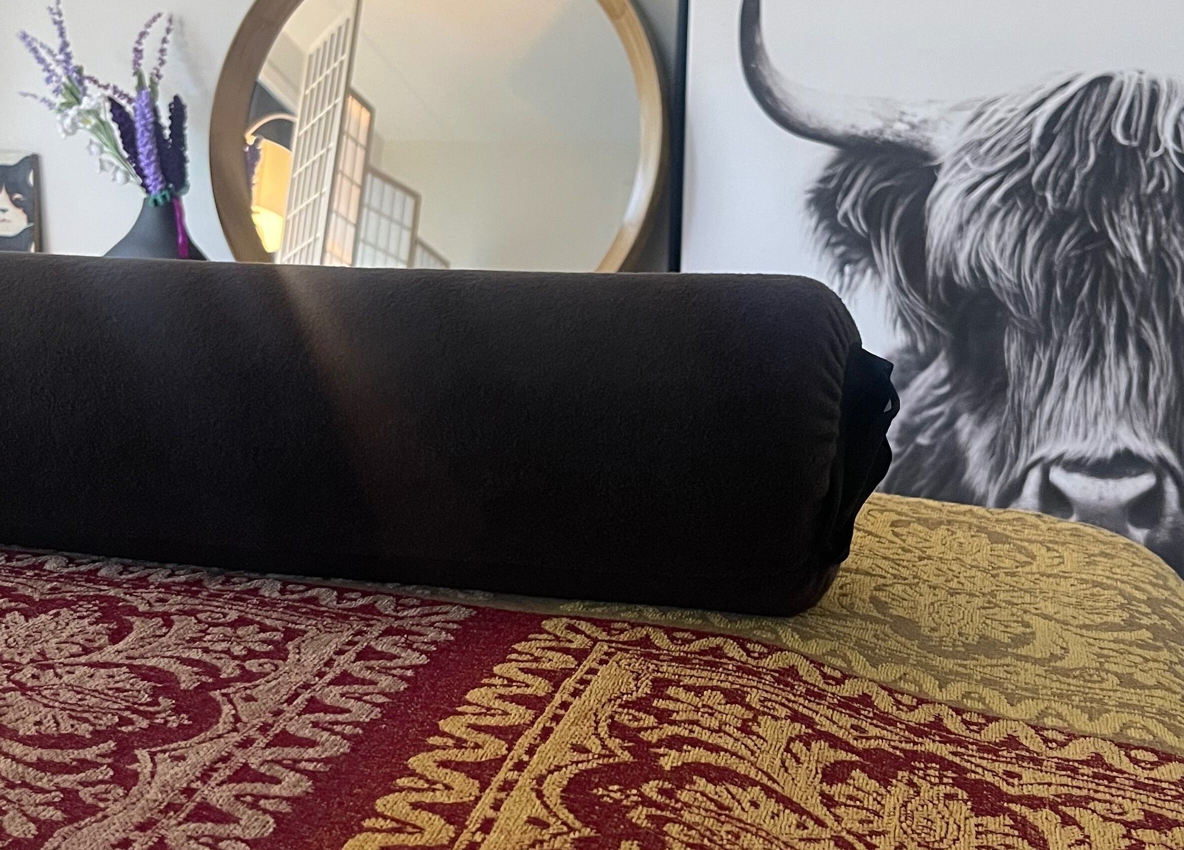 Elegant decor at The Body Lab, Richmond, Tasman Region, NZ with a rolled black towel on patterned fabric.