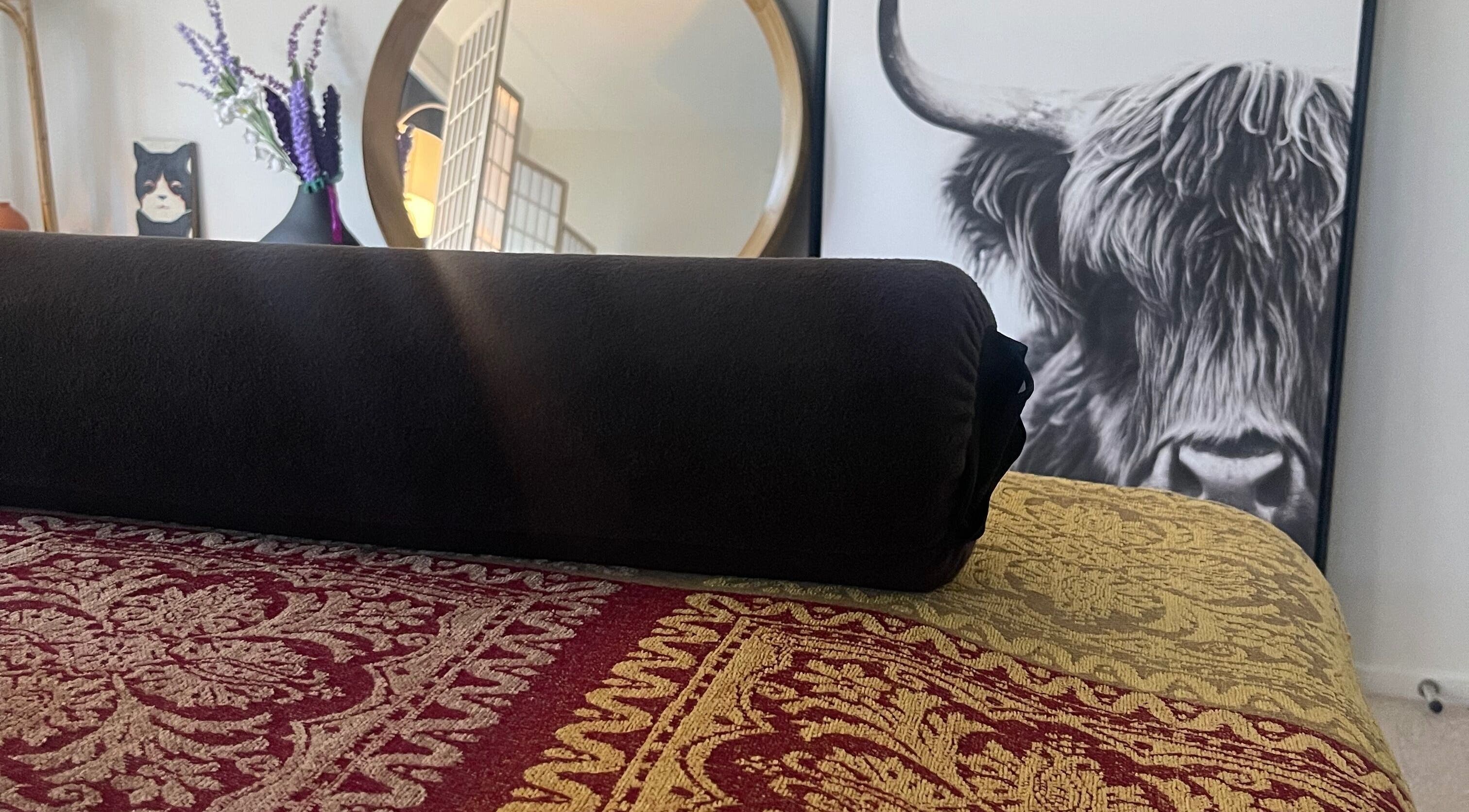 Elegant decor at The Body Lab, Richmond, Tasman Region, NZ with a rolled black towel on patterned fabric.