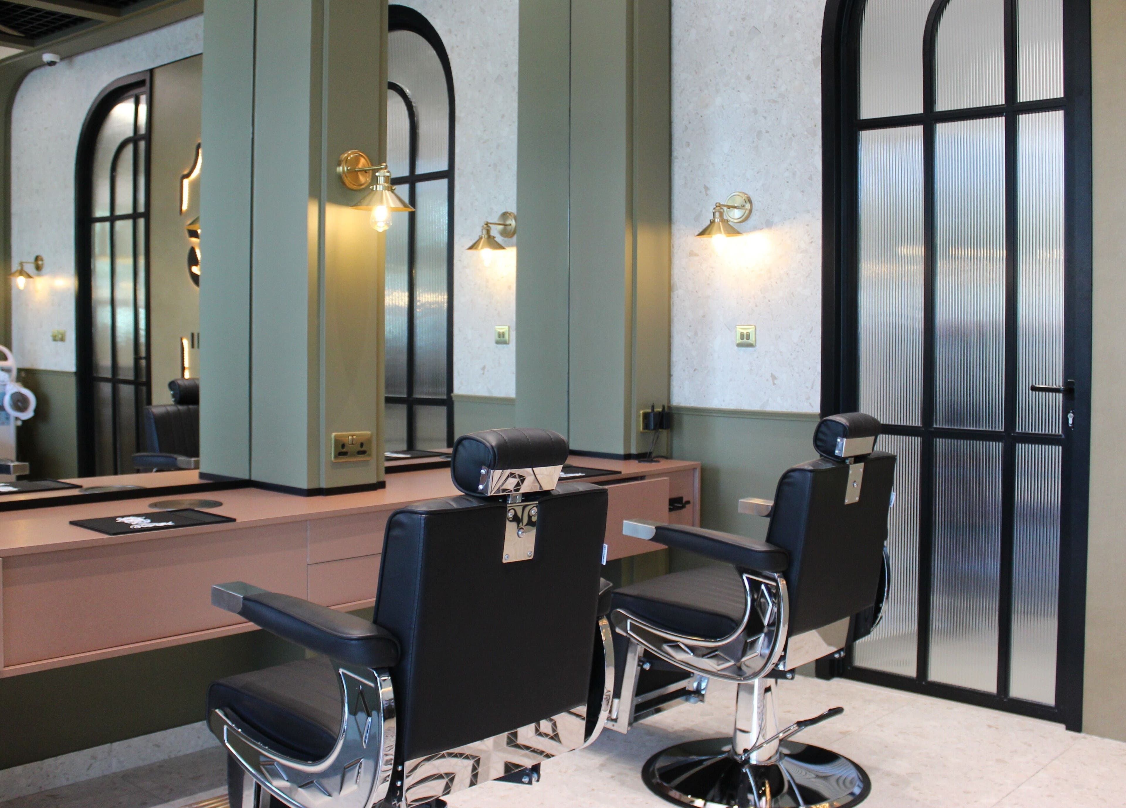 Modern interior of Qabbani Barbers in Dubai, Dubai, AE featuring chic black chairs and stylish decor.