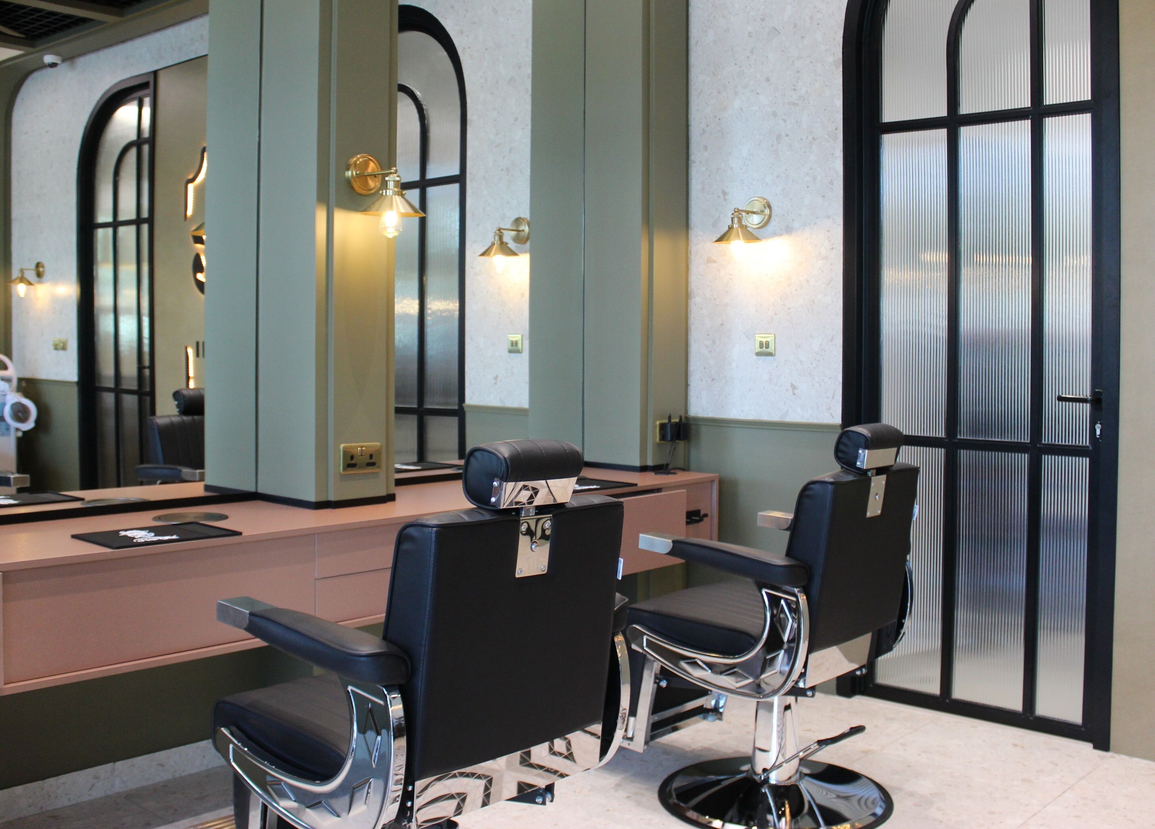 Modern interior of Qabbani Barbers in Dubai, Dubai, AE featuring chic black chairs and stylish decor.