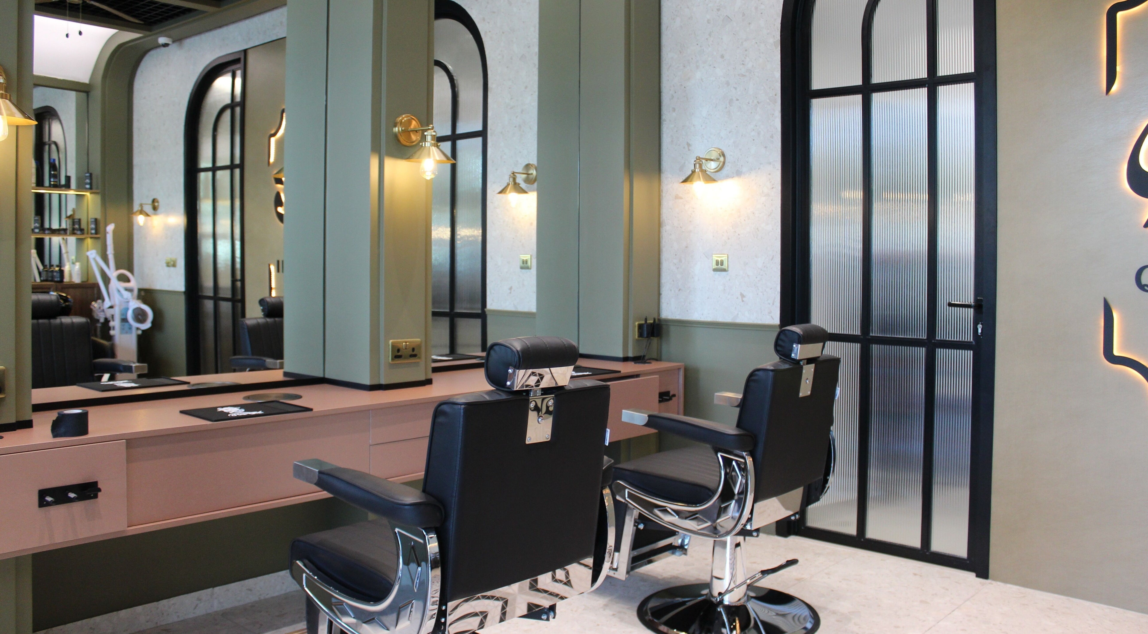 Modern interior of Qabbani Barbers in Dubai, Dubai, AE featuring chic black chairs and stylish decor.