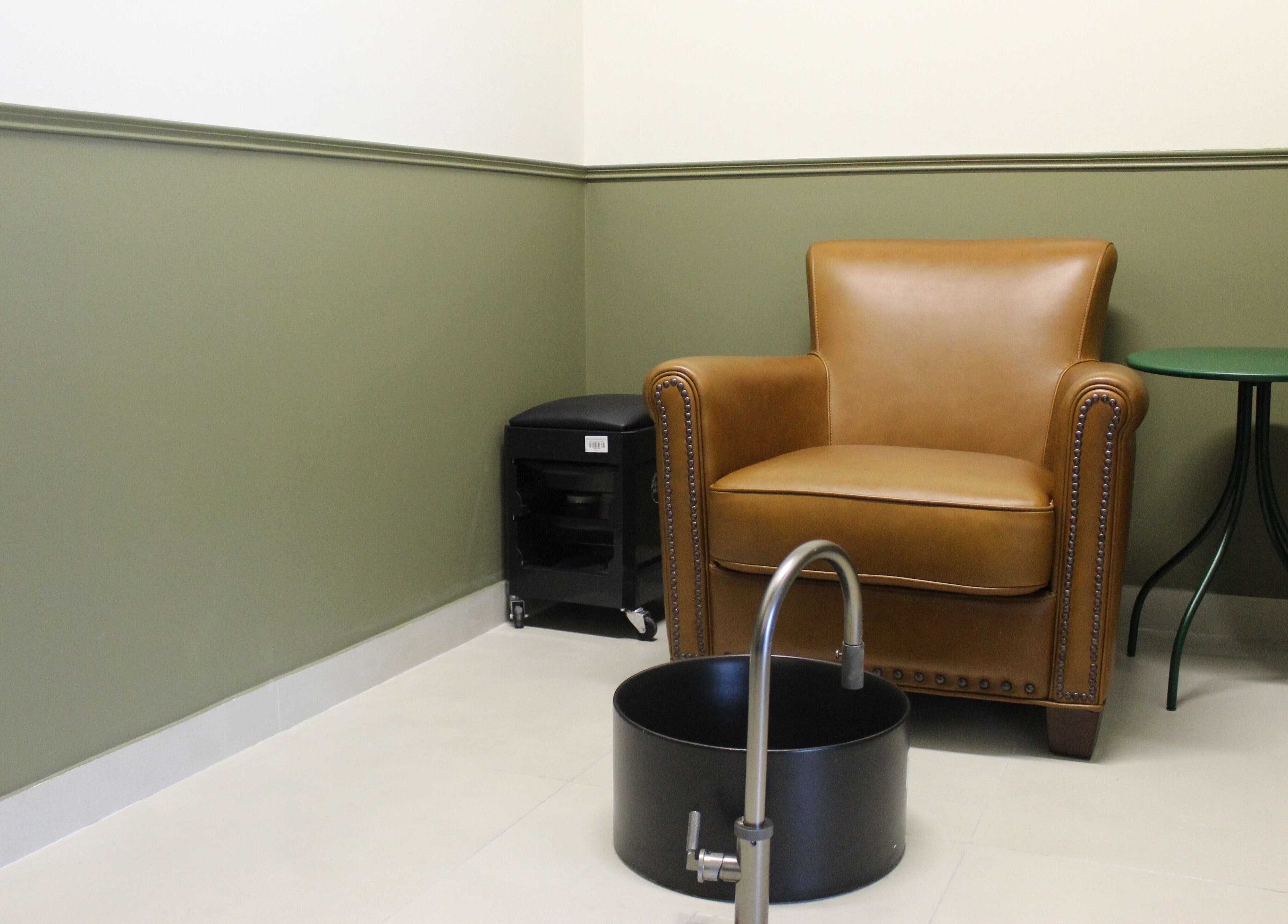 Comfortable seating area at Qabbani Barbers, Dubai, Dubai, AE, featuring a leather chair and a foot spa.