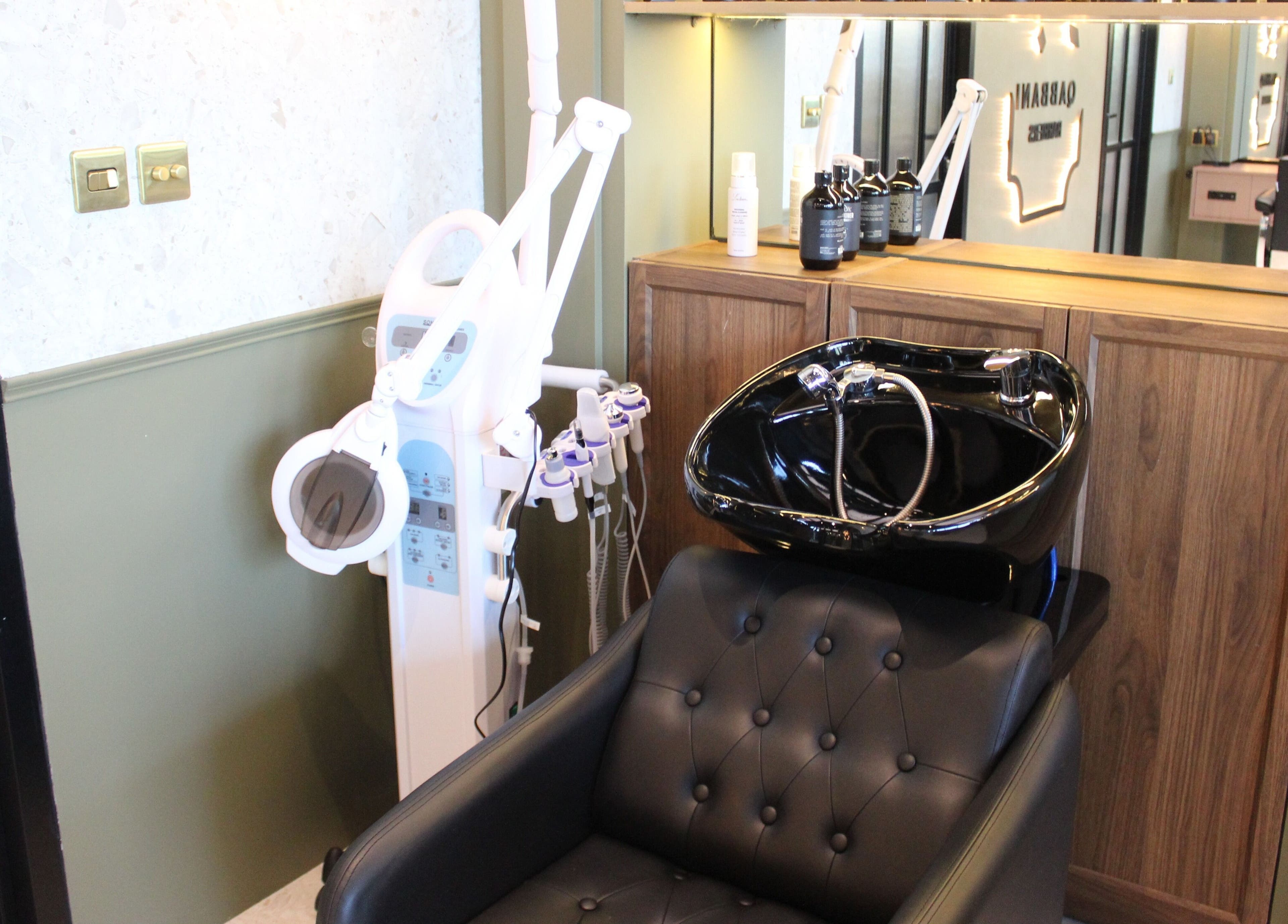 Luxurious salon station at Qabbani Barbers, Dubai, Dubai, AE, featuring a sleek black washbasin and equipment.