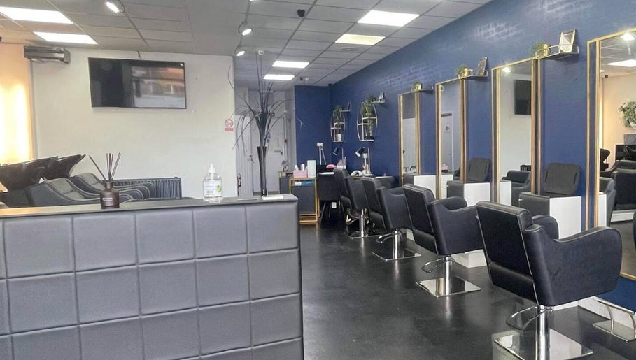 Modern salon interior at Strands of Perfection, Telford, England, GB, featuring stylish mirrors and chairs.