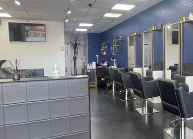Modern salon interior at Strands of Perfection, Telford, England, GB, featuring stylish mirrors and chairs.