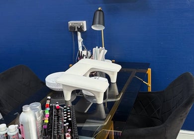 Modern nail station at Strands of Perfection, Telford, England, GB, with black chairs and nail products.