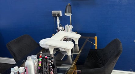 Modern nail station at Strands of Perfection, Telford, England, GB, with black chairs and nail products.
