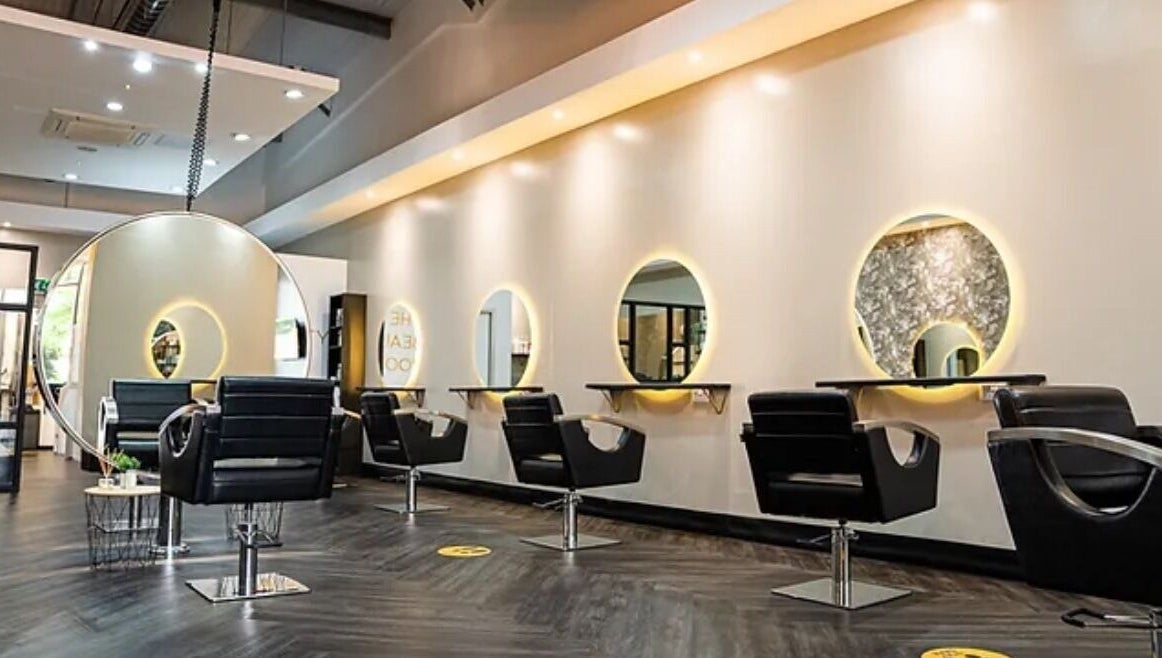 Modern salon interior at Steadman & Co, Peterborough, England, GB with sleek chairs and illuminated mirrors.